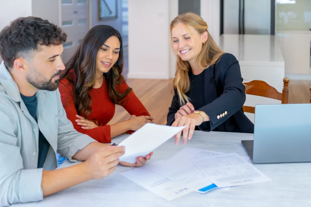A mortgage broker and clients reviewing financial documents for a non-conforming lending application in a professional Melbourne office.